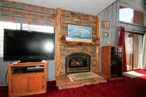 a living room with a tv and a fireplace at Mammoth Ski & Racquet Club #074 in Mammoth Lakes +4 photos