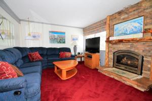 a living room with a blue couch and a fireplace at Mammoth Ski & Racquet Club #074 in Mammoth Lakes