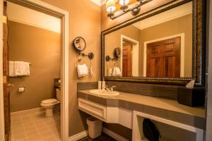 a bathroom with a sink, mirror, and toilet at Pine Ridge Inn in Bend