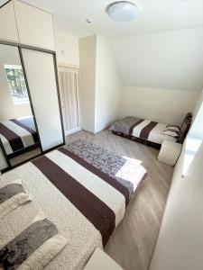 1 dormitorio con 2 camas y espejo en Gintarinis pajuris, en Karklė