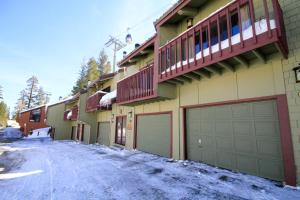 a house with two garage doors on a snowy street at Courchevel #51 in Mammoth Lakes