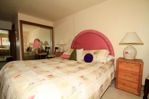 Schlafzimmer mit einem großen Bett mit einem rosa Kopfteil in der Unterkunft Mountainback #40, Loft, Corner in Mammoth Lakes