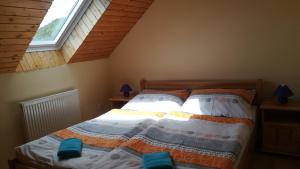 a bedroom with a bed in a attic with a window at Rekreačné zariadenie Chmelisko in Pružina