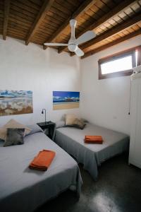 two beds in a room with a ceiling fan at VILLA RELAX, LA GRACIOSA in Caleta de Sebo
