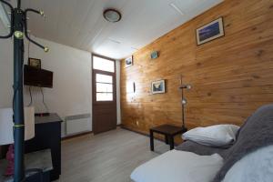 een slaapkamer met een houten muur met een bed en een tafel bij T1 situé à 100 m des thermes in Aix-les-Bains