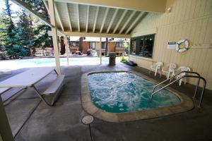 una bañera de hidromasaje en un patio con mesa y sillas en Discovery 4 #113, en Mammoth Lakes 8 fotos más