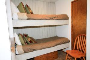 Una habitación con dos literas con almohadas y una silla. en Discovery 4 #113, en Mammoth Lakes