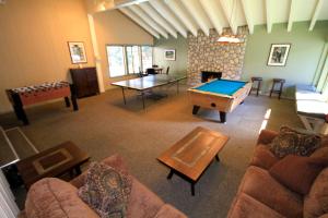 a living room with a ping pong table and a room with a fireplace at Discovery 4 142 Loft in Mammoth Lakes