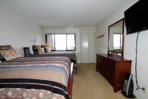 a bedroom with two beds and a dresser with a mirror at Mammoth Ski & Racquet Club #62 in Mammoth Lakes