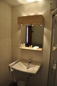 ein Bad mit einem Waschbecken und einem Spiegel in der Unterkunft Hotel Grauleshof in Aalen