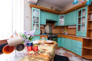 テルノーピリにあるПрекрасная квартира в самом центреのキッチン(緑のキャビネット、花のテーブル付)
