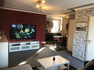 ein Wohnzimmer mit einem Flachbildfernseher an der Wand in der Unterkunft Ferienwohnung Schwede in Surendorf