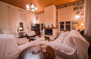 a living room with white couches and a fireplace at Laconian Collection "En Hatipi" in Sparta