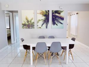 a white dining room with a white table and chairs at The Jasmine Apartments in Fort Lauderdale