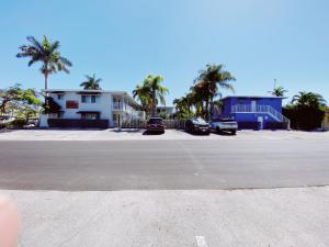 a parking lot with cars parked in front of a building at The Jasmine Apartments in Fort Lauderdale