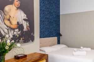 a bedroom with a painting on the wall next to a bed at Donna Lena Relais Napoli in Naples