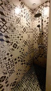 La salle de bains est pourvue d'une douche et d'un mur carrelé. dans l'établissement "LE PAVILLON" Maisonnette 150 m gare des Aubrais, à Fleury-les-Aubrais
