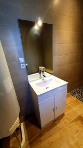 y baño con lavabo blanco y espejo. en "LE PAVILLON" Maisonnette 150 m gare des Aubrais, en Fleury-les-Aubrais