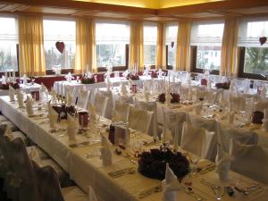 een kamer gevuld met tafels met wit tafellinnen bij Hotel Grauleshof in Aalen