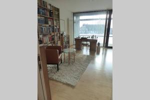 a living room with a library with a desk and a chair at Im Herzen von Aschaffenburg in Aschaffenburg