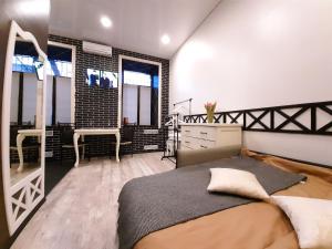 a bedroom with a bed and a black brick wall at Gerda - 1-комн. Студия в Центре in Kremenchuk