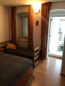 1 Schlafzimmer mit 2 Betten und einem großen Fenster in der Unterkunft Apartmenthaus"Kala" in Crikvenica