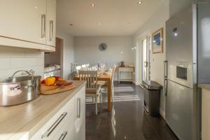 a kitchen with a table and a dining room at Sea Folly in Perranporth