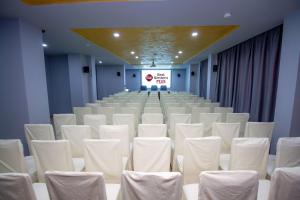 a conference room with white chairs and a stage at Best Western PLUS Premium Inn in Sunny Beach