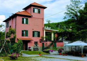 a large pink house with a garden in front of it at La Torretta bed & breakfast in Torriglia