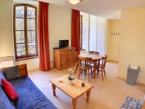 a living room with a blue couch and a table at Appartement 208 Résidence du Grand Hotel Aulus-les-Bains in Aulus-les-Bains