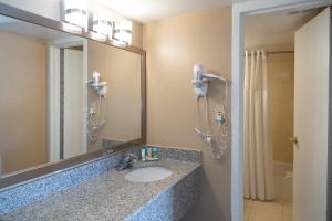 a bathroom with a sink and a mirror and a shower at Hotel Pentagon in Arlington +37 photos