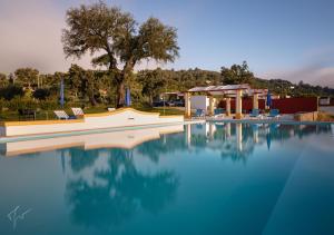 a swimming pool with chairs and a gazebo at Cabecas do Reguengo in Portalegre