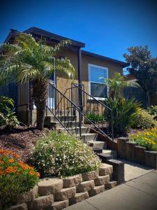 a house with a palm tree and stairs in front of it at Blue Heron Cottages in San Diego