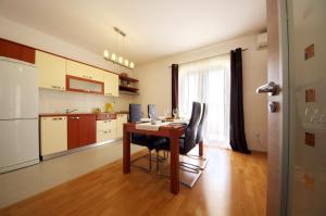 eine Küche mit einem Tisch und Stühlen im Zimmer in der Unterkunft Apartmani Emili in Sukošan