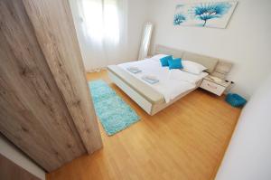 ein kleines Schlafzimmer mit einem Bett und einem blauen Teppich in der Unterkunft Apartmani Emili in Sukošan