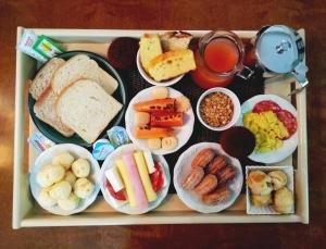 a tray filled with different types of breakfast foods at Pousada Canasvieiras in Florianópolis
