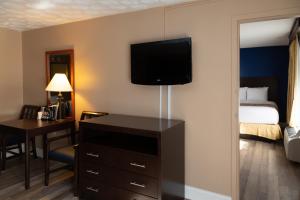 a hotel room with a bed and a desk and a television at Hotel Pentagon in Arlington