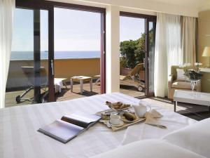 a hotel room with a tray of food on a bed at GH Palazzo Suite & SPA in Livorno