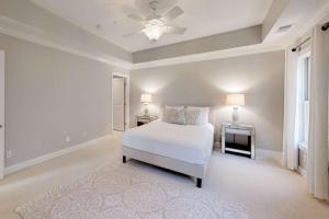 a white bedroom with a bed and a ceiling fan at Promenade Overlook in Bluffton