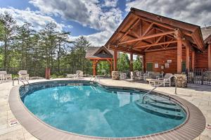 a swimming pool in front of a log cabin at 2 Mi to Attractions Pigeon Forge Condo in Pigeon Forge