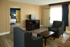 a living room with two chairs and a room with a bed at Hotel Pentagon in Arlington