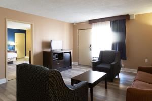 a living room with a couch and chairs and a television at Hotel Pentagon in Arlington