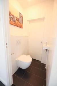 ein Badezimmer mit einem weißen WC und einem Waschbecken in der Unterkunft Water Villa Workum in Workum