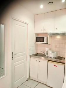 a kitchen with white cabinets and a white door at Rive gauche in Cuffies