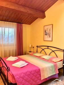 a bedroom with a large bed with a pink blanket at La Casetta Di Atri in Atri