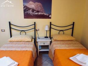 duas camas sentadas uma ao lado da outra num quarto em La Casetta Di Atri em Atri
