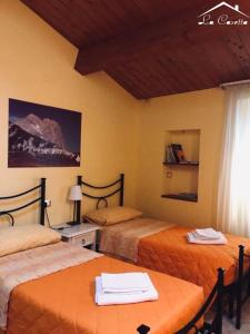 アトリにあるLa Casetta Di Atriのベッド2台、テーブル、窓が備わる客室です。