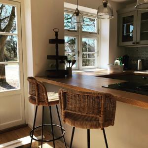 a kitchen with two bar stools and two windows at Katjas Kate in Prerow