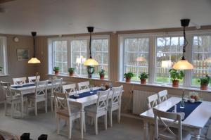 a dining room with tables and chairs and windows at Hotel & Pensionat Björkelund in Stenbrohult