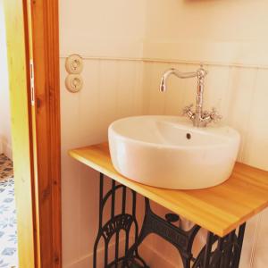 ein Badezimmer mit einem weißen Waschbecken auf einer Holztheke in der Unterkunft Katjas Kate in Prerow